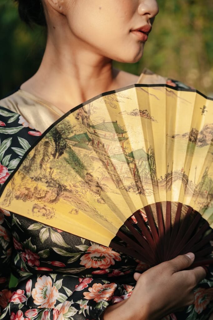 close up shot of a woman holding a hand fan