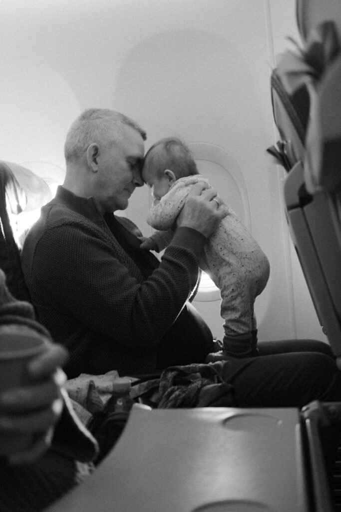 man holding baby in airplane